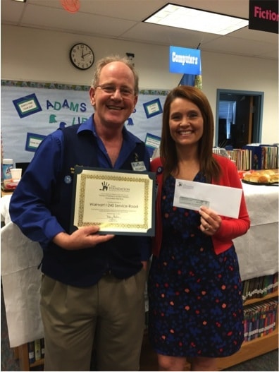 Image of man and woman holding awards