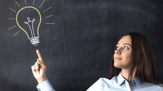 teacher pointing to lightbulb drawn on chalkboard