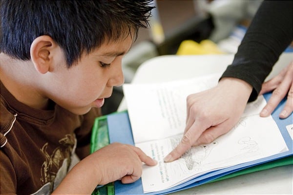 teacher helping student read